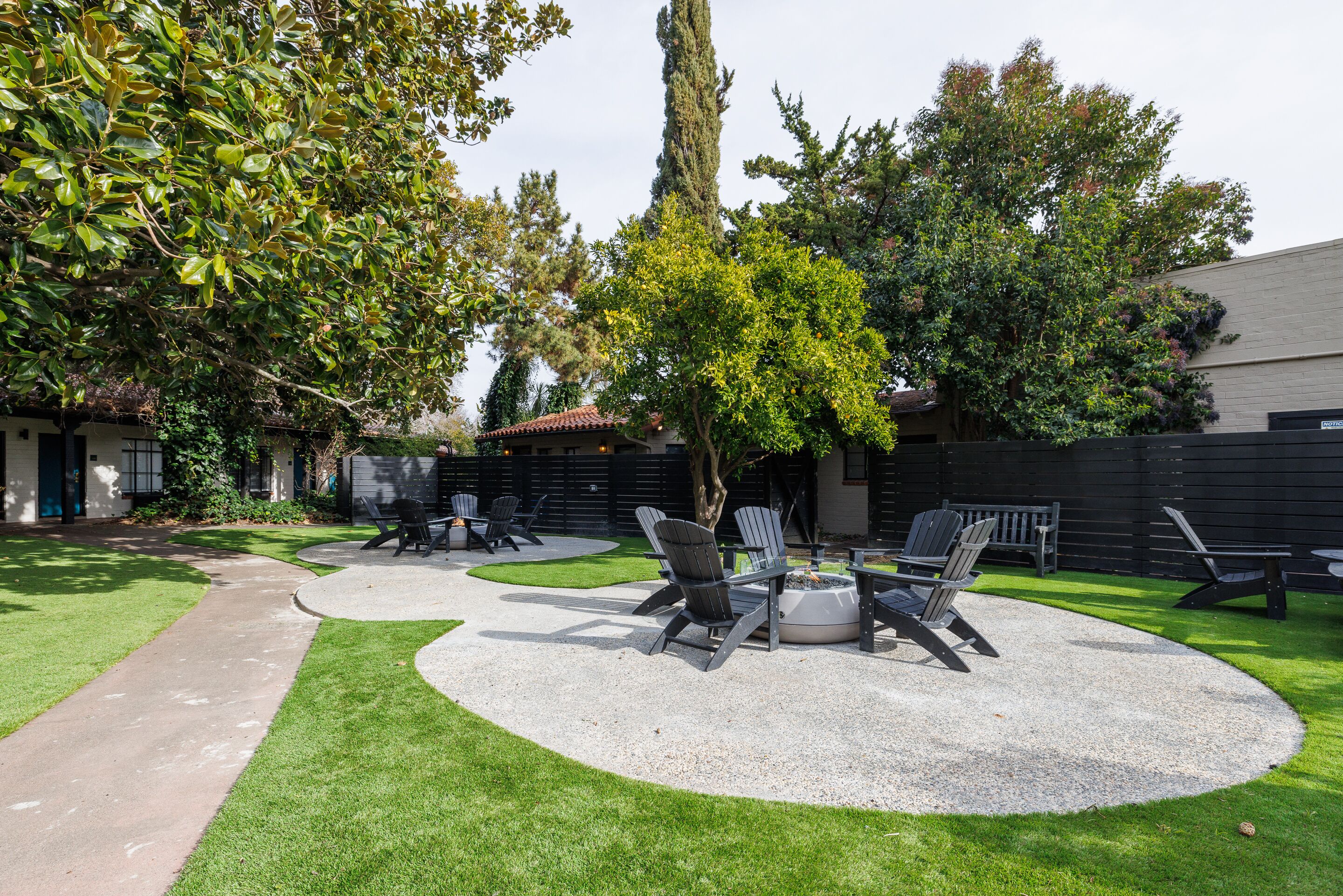 A patio area with outdoor seating, a fire pit, and a well-maintained lawn.