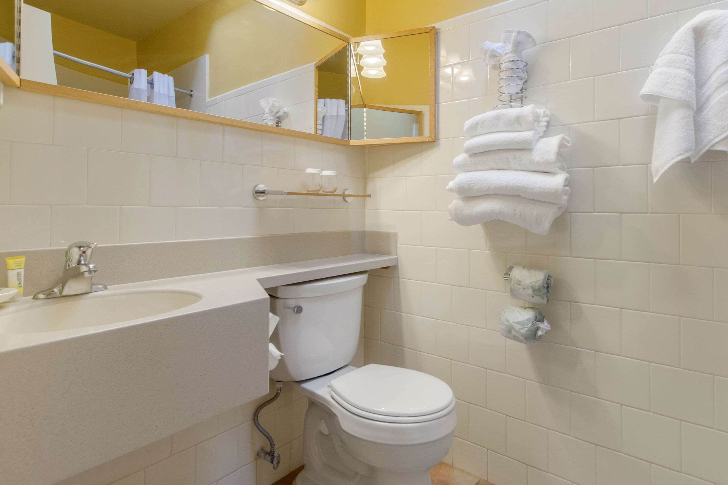A bathroom with a sink, toilet, and towel rack.
