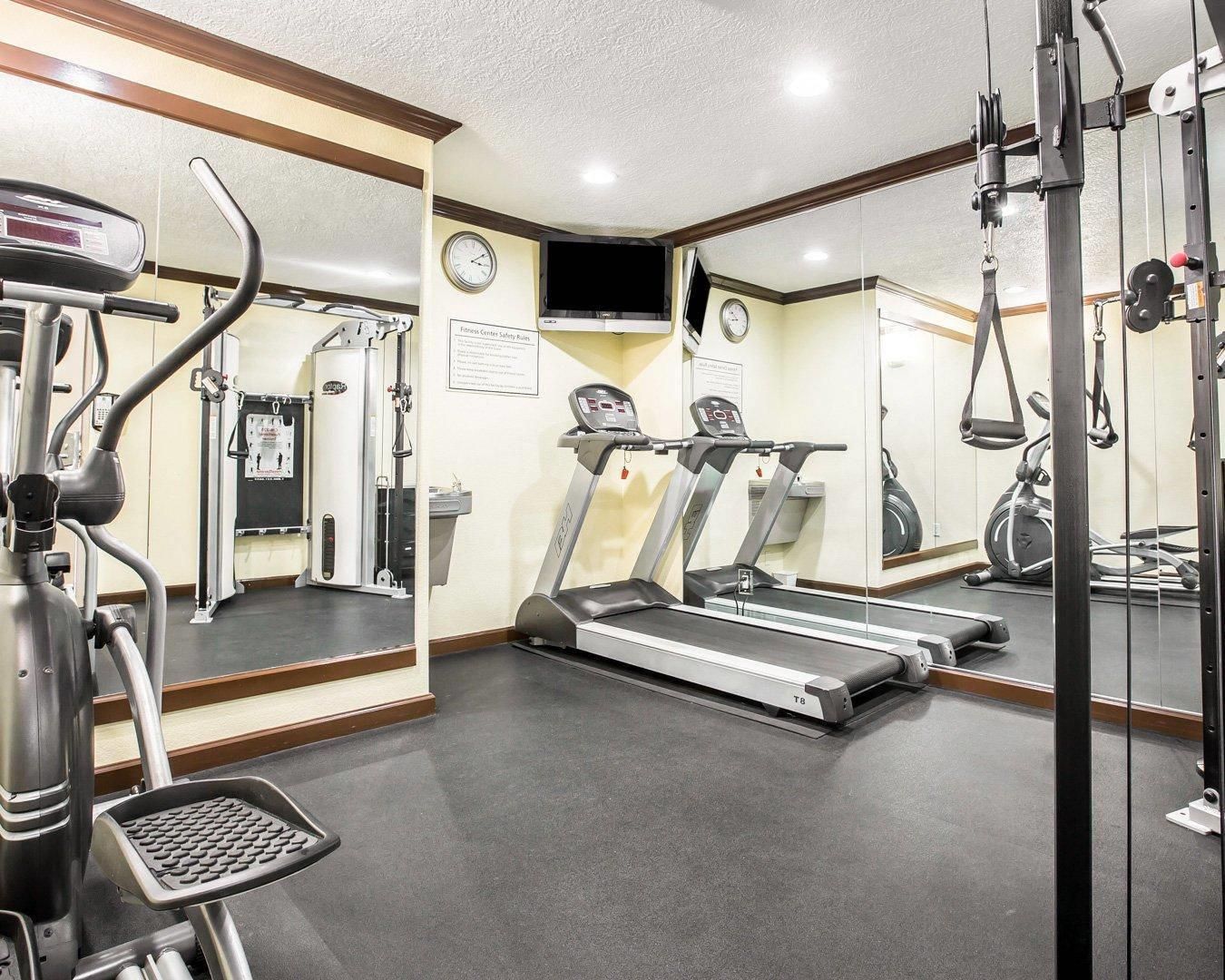 Un gimnasio con cintas de correr, una bicicleta estática y máquinas de pesas.