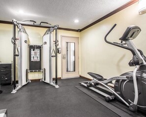 A gym with a treadmill, weight machines, and a mirror. - Quality Inn San Diego I-5 Naval Base (San Diego)