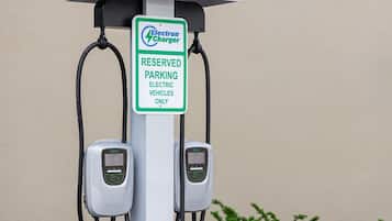 Un cargador Electrón con un letrero que indica estacionamiento reservado únicamente para vehículos eléctricos.