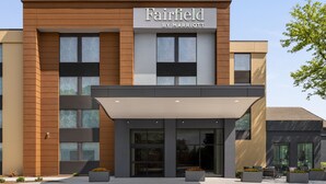 Un hotel Fairfield by Marriott con fachada moderna, ventanas grandes y zona de estar al aire libre.