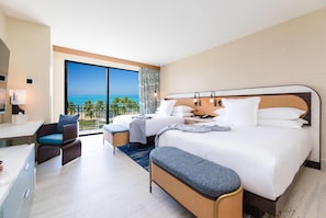 A hotel room with a large balcony, a bed, a desk, and a chair.