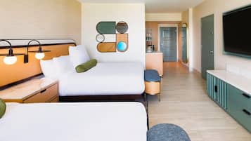 A hotel room with a bed, bedside tables, a TV, and a kitchenette.