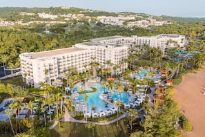 A resort with multiple buildings, a swimming pool area, and a beach.
