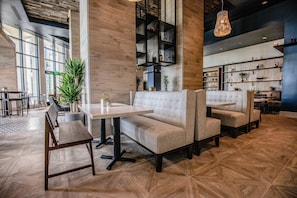 A modern interior with a seating area, wooden flooring, and a large window.