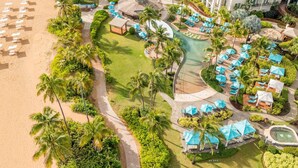 An aerial view of a resort with a beach, a pool area, and a building with multiple balconies. - Wyndham Grand Rio Mar Rainforest Beach and Golf Resort (Río Grande)