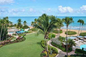 Un resort con piscina, playa y palmeras.