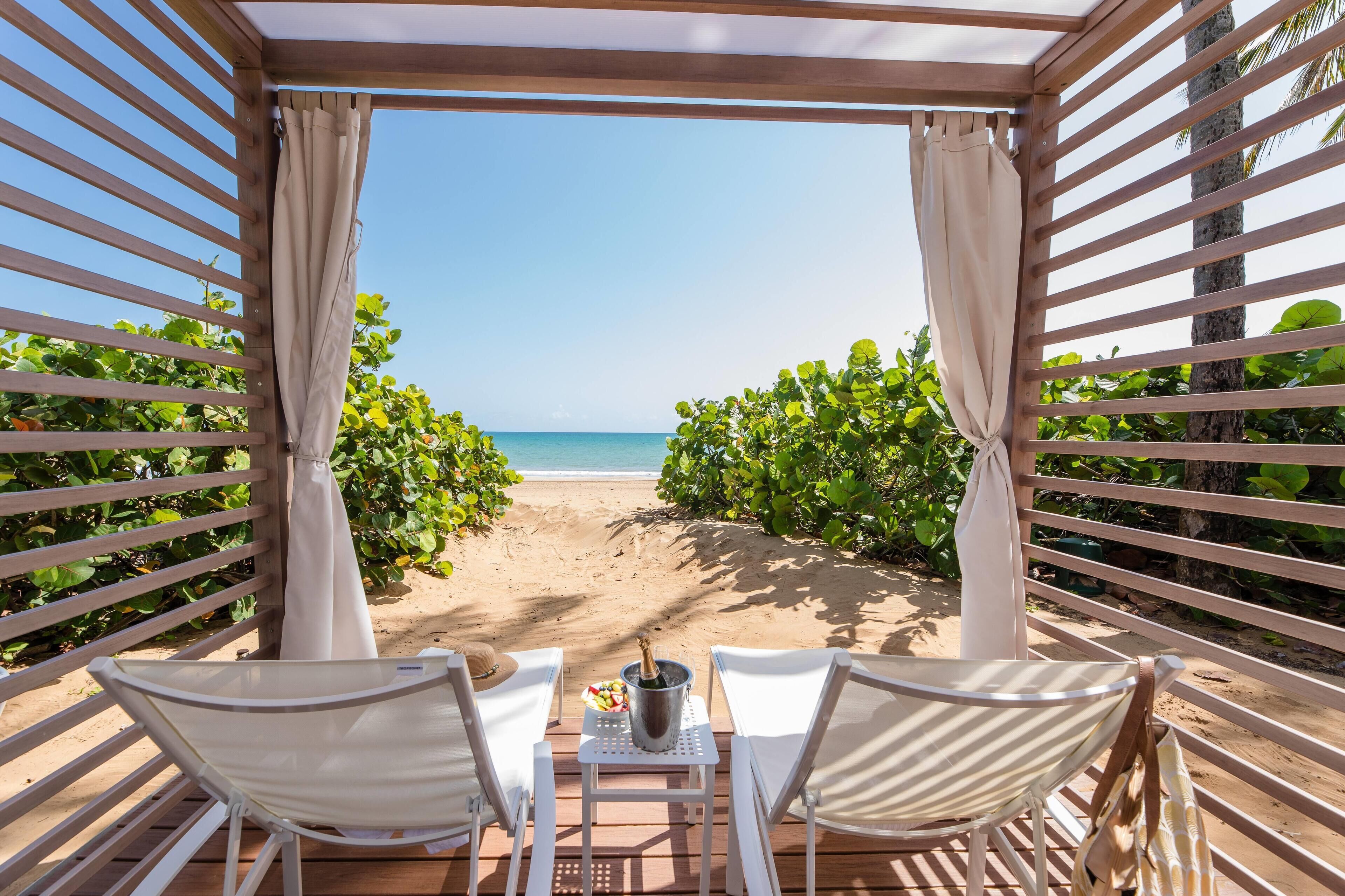 En la playa, playa de arena blanca y camas de playa (con cargo) 