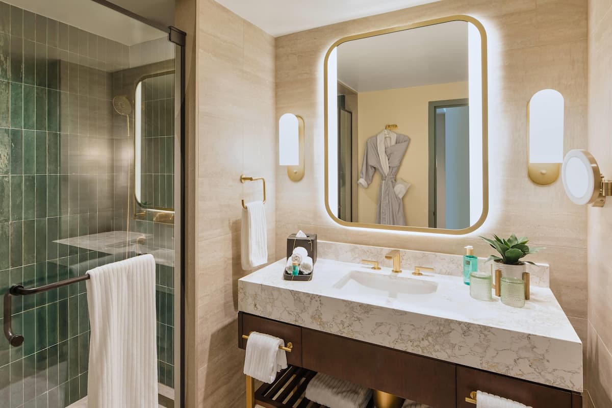 Baignoire, articles de toilette griffés, séchoir à cheveux