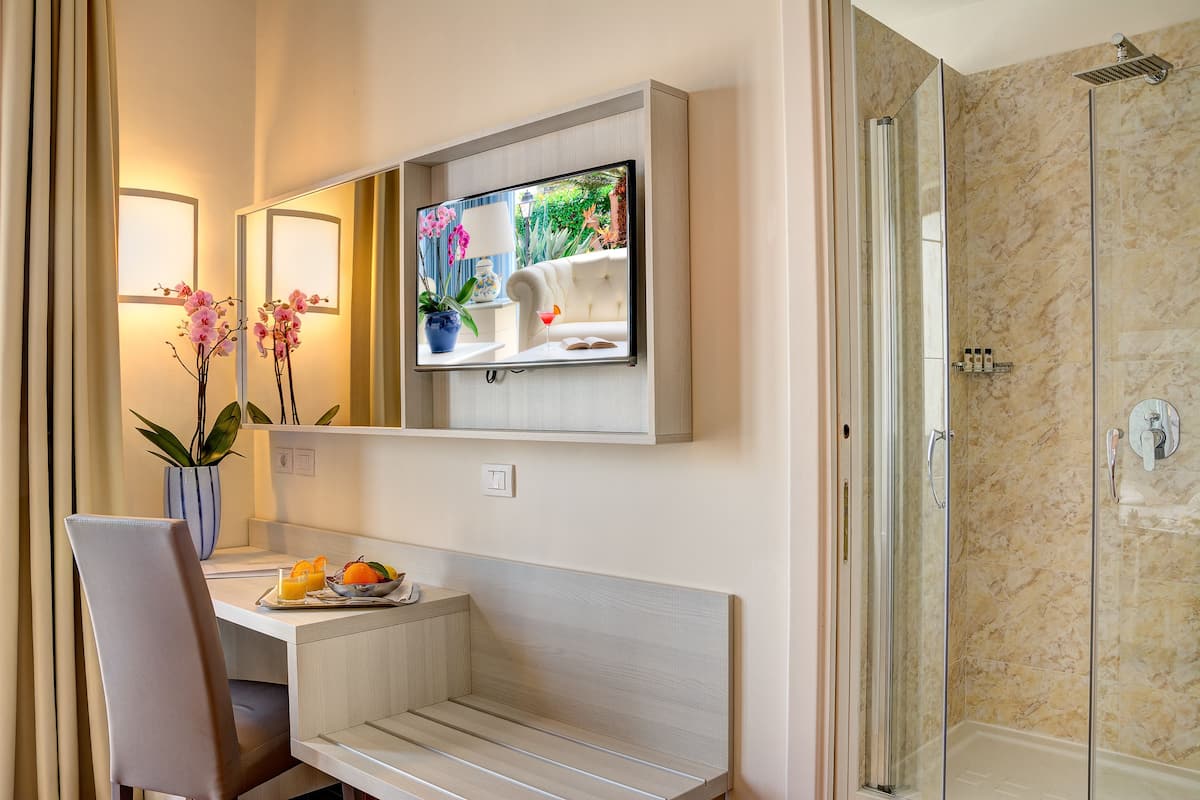 A modern bathroom with a shower, a vanity with a mirror, and a seating area with a table and chairs.