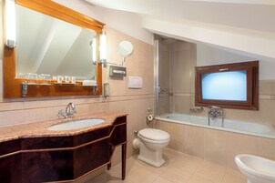 Un bagno con lavabo in marmo, un water, una vasca da bagno e una doccia.