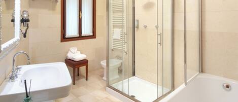 A modern bathroom with a glass-enclosed shower, a large bathtub, a sink, and a vanity.