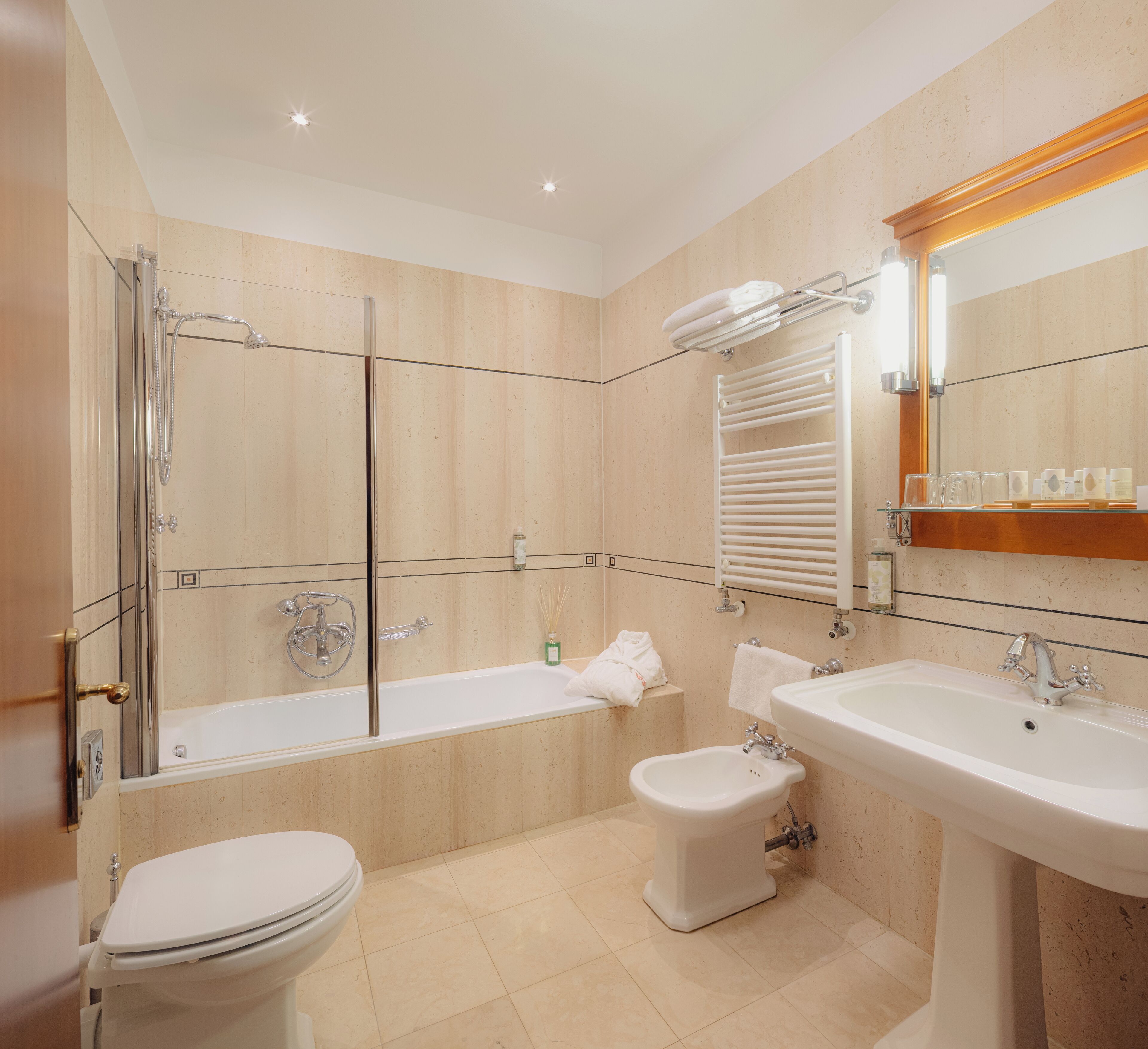 A modern bathroom with a bathtub, toilet, bidet, and sink.