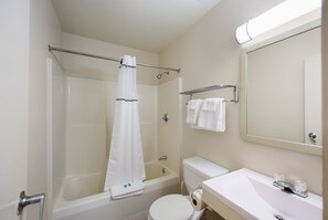 Un bagno con vasca, WC, lavandino e porta asciugamani.