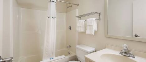 A bathroom with a bathtub, toilet, and sink.