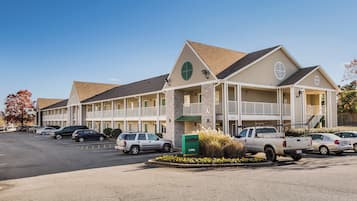 A motel with a two-story structure, a covered parking area, and a green mailbox.