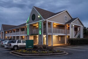 A multi-story motel with a central courtyard, balconies, and a parking lot.