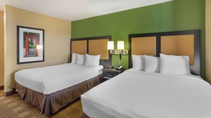 A hotel room with two beds, a nightstand with a lamp, and a framed picture on the wall. - Extended Stay America Suites Nashville Brentwood South (Brentwood)