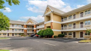 A multi-story hotel with a central courtyard, balconies, and a parking lot. - Extended Stay America Select Suites - Chattanooga - Airport (Chattanooga)