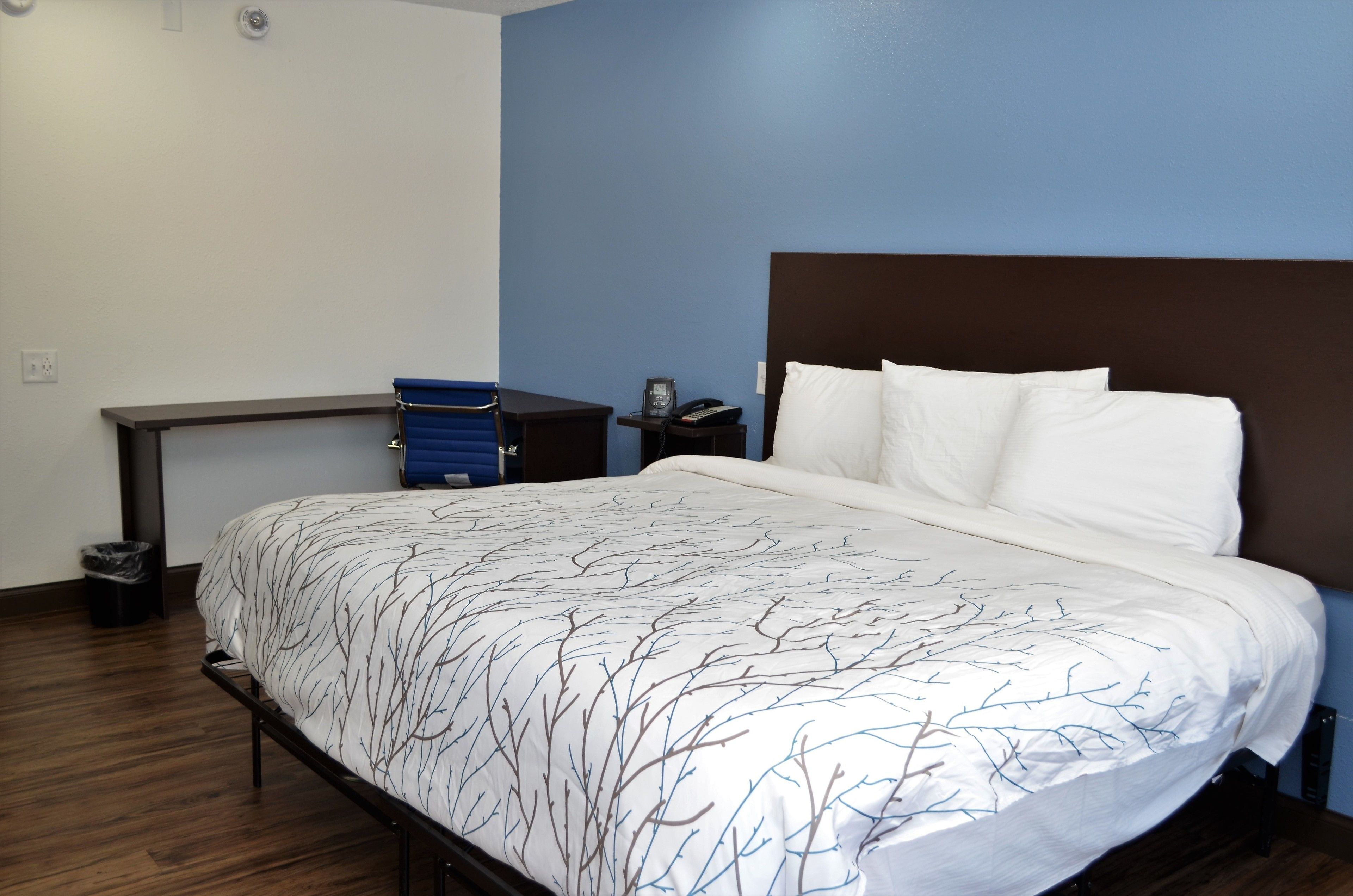 Une chambre d’hôtel avec un lit, un bureau et une chaise.