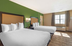 A hotel room with two beds, a large window with curtains, an air conditioning unit, and a lamp on the nightstand. - Extended Stay America Select Suites Nashville Airport (Nashville)