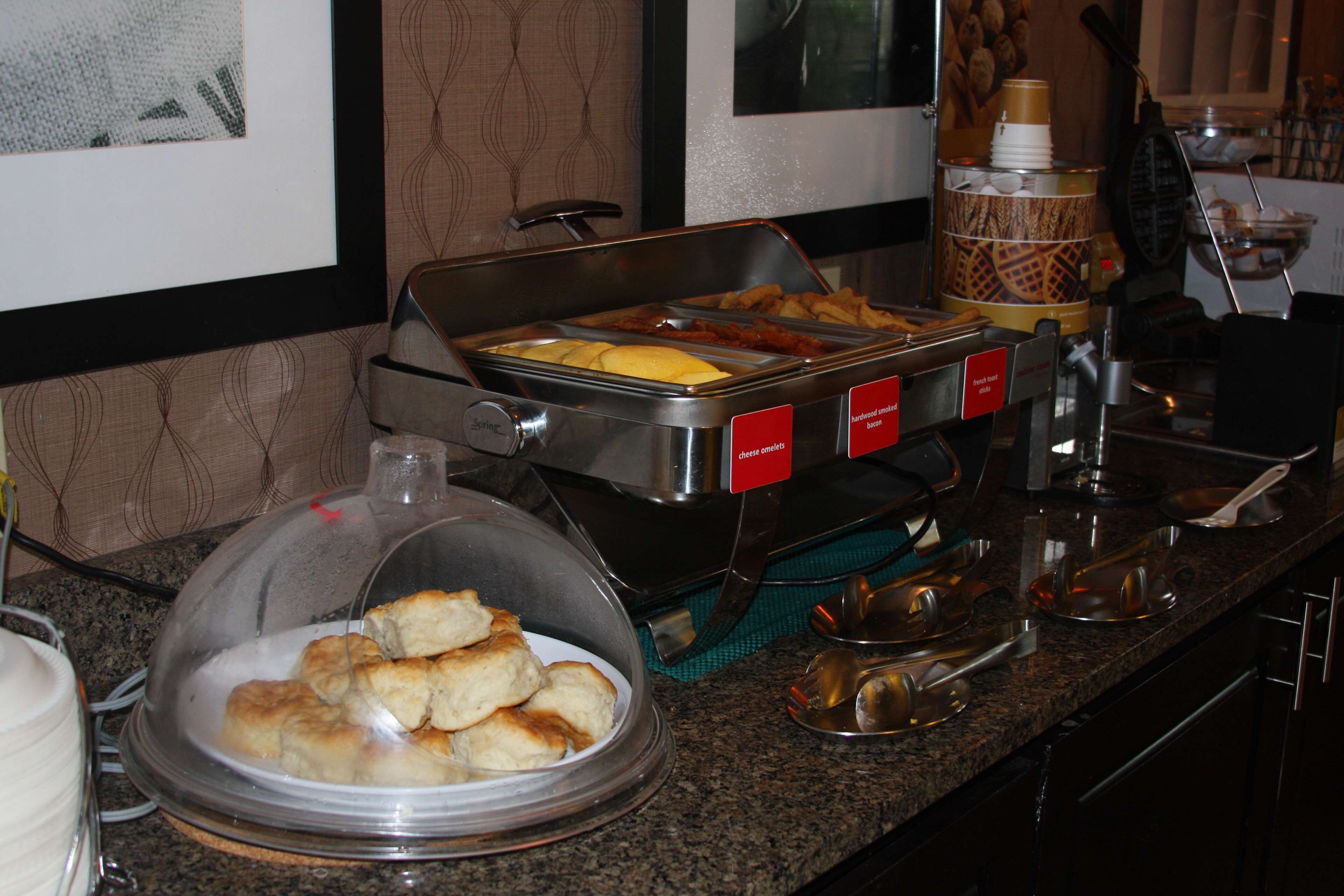 A buffet setup with various food items and utensils.