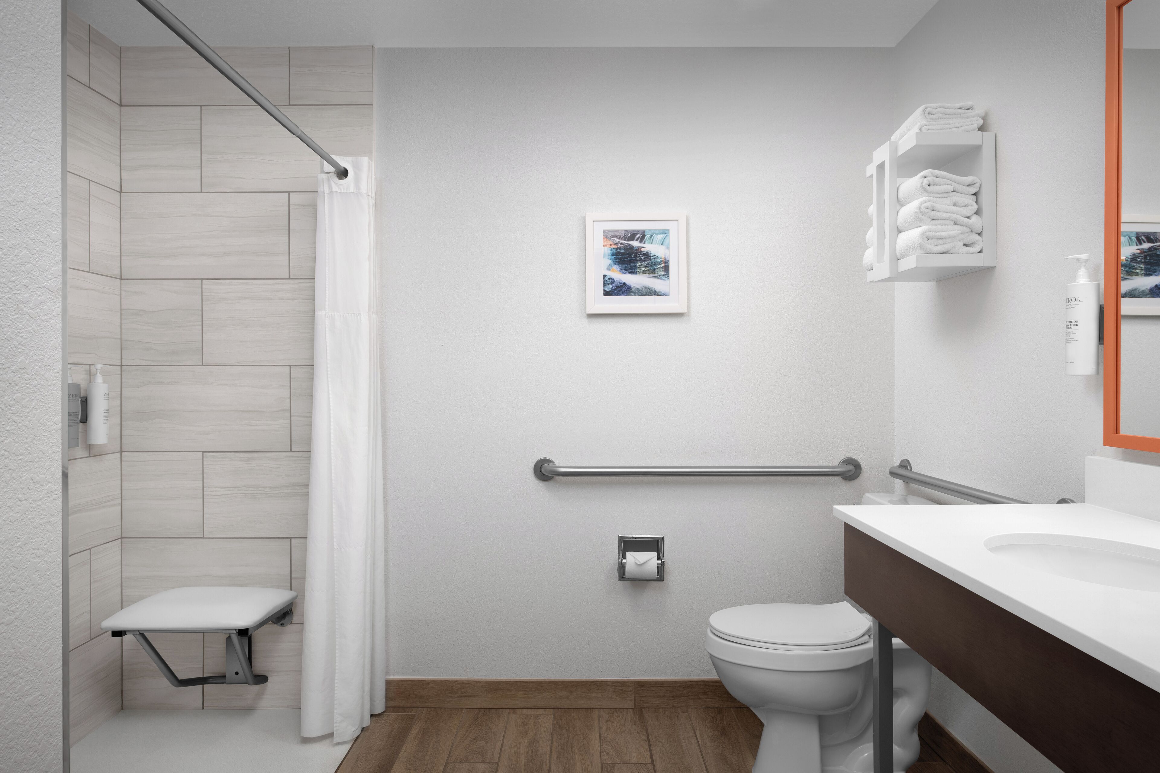 Un baño moderno con ducha, inodoro y lavamanos.