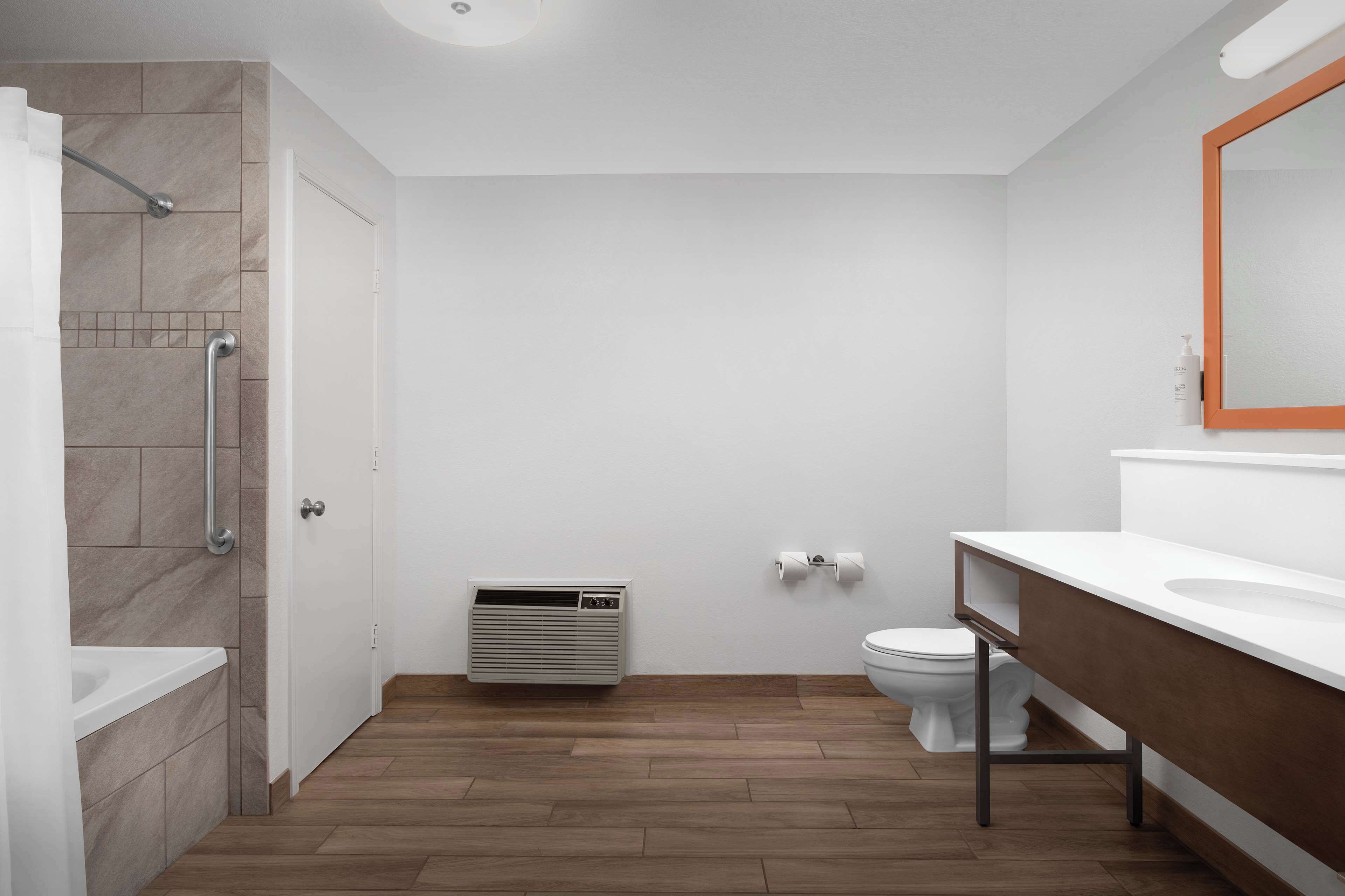 Un baño moderno con ducha, inodoro y lavamanos.