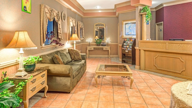 Eine Lobby mit einer Couch, einem Couchtisch und einer Rezeption.
