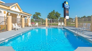 Ein Schwimmbecken mit Liegestühlen und einem Days Inn Schild.