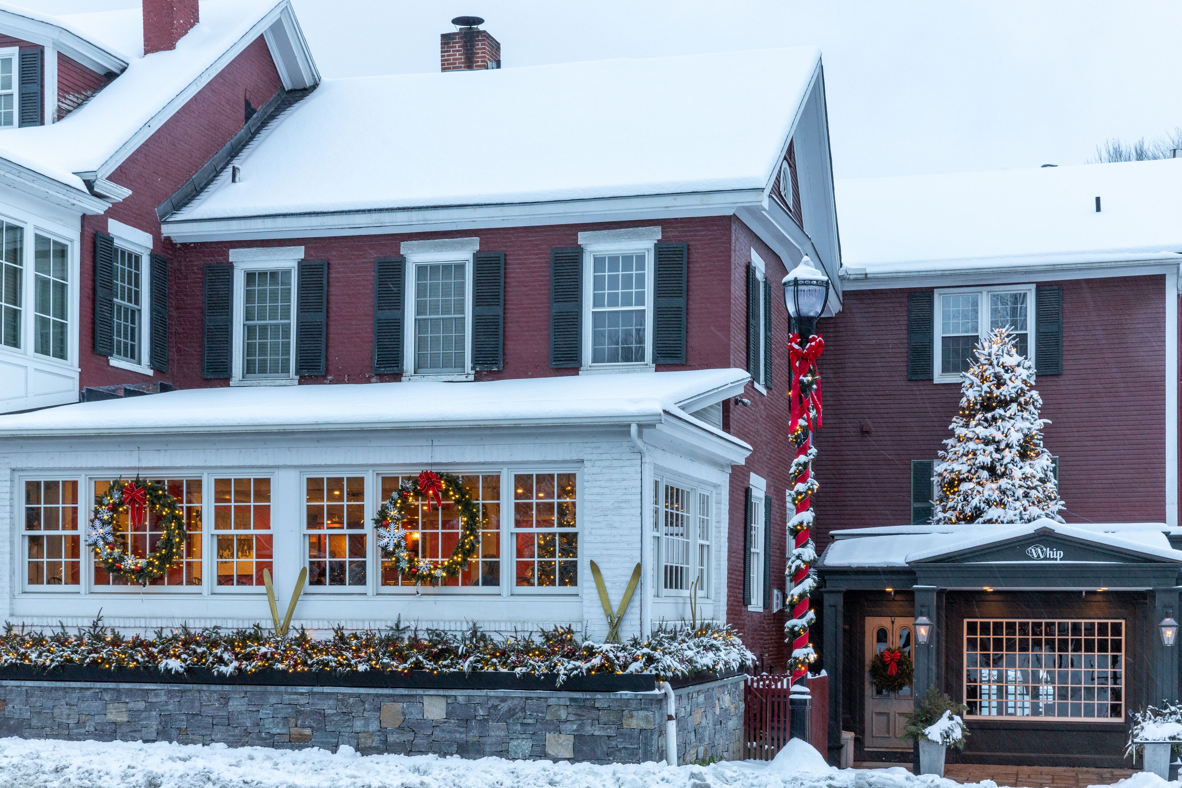 A two-story building with a snow-covered roof and a brick facade.