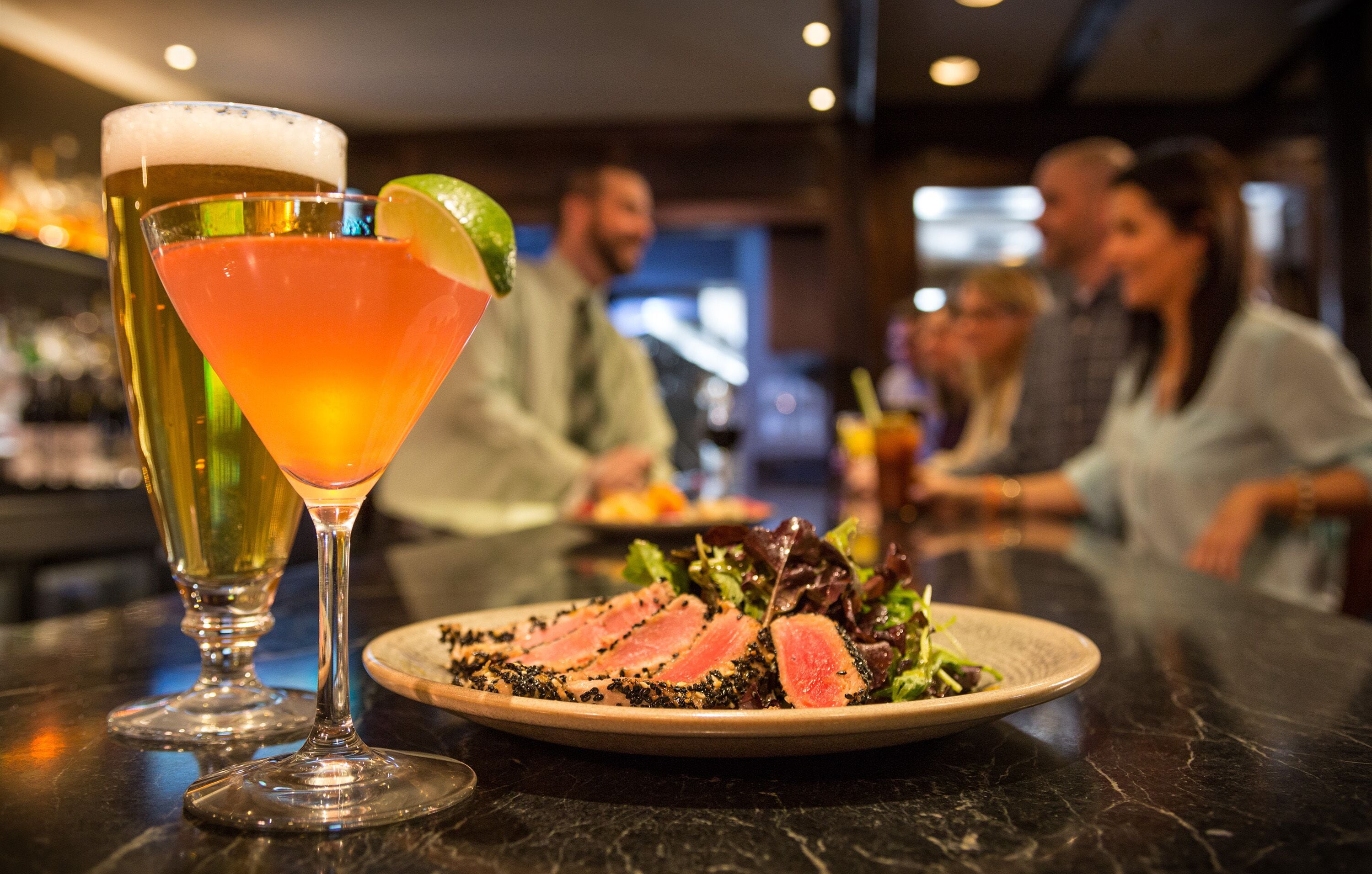 Een barsetting met een martini-glas en een bord eten.