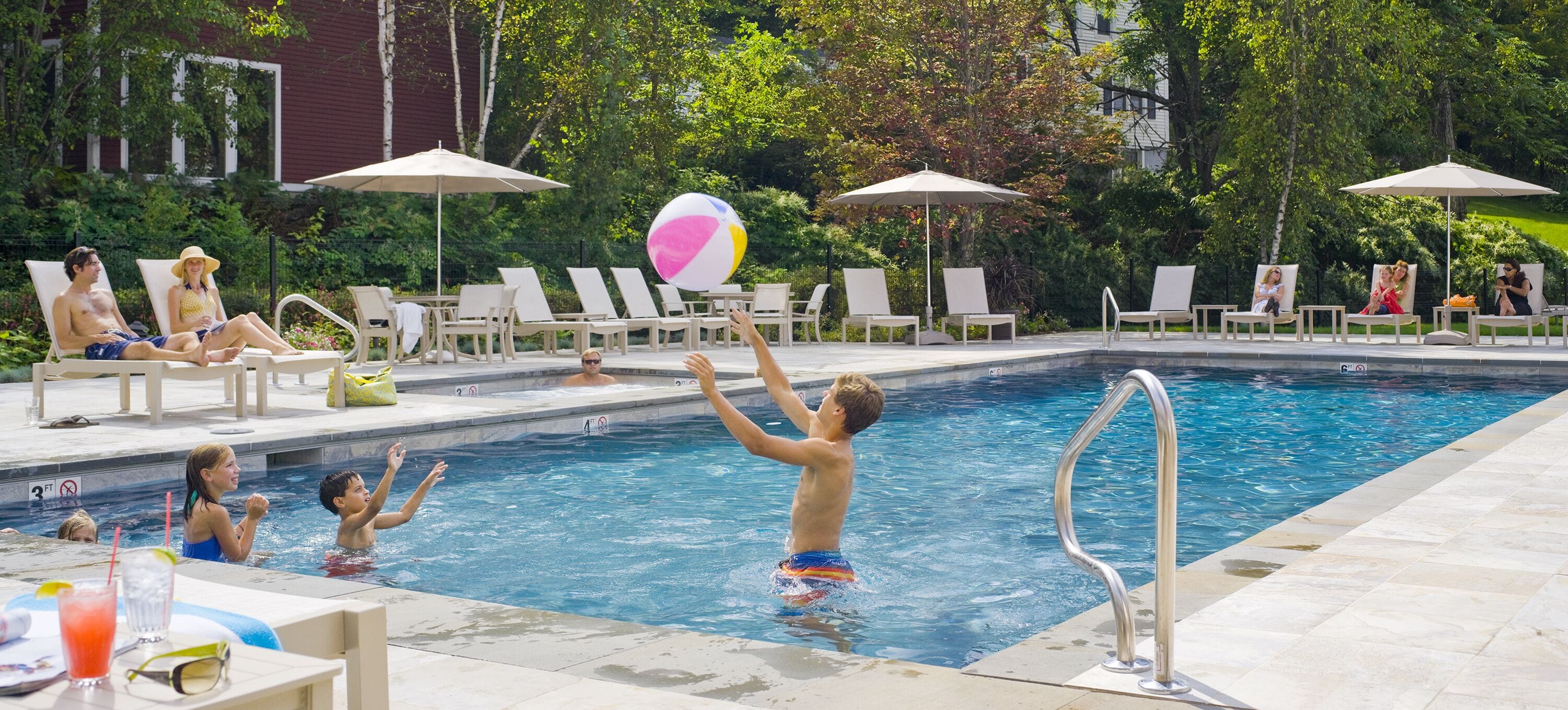 Una piscina con lettini e ombrelloni.