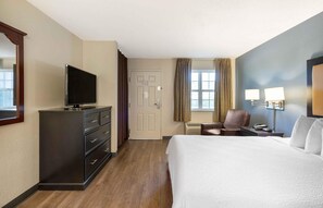 A hotel room with a bed, a TV on a dresser, a desk with a chair, and a window with curtains. - Extended Stay America Suites Chesapeake Crossways Blvd (Chesapeake)