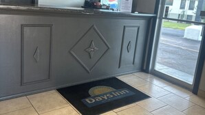 A reception area with a check-in counter, a pet policy sign, a manager on duty sign, and a Days Inn logo on the floor mat. - Days Inn by Wyndham Jacksonville (Jacksonville)