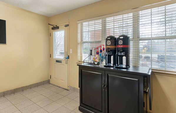 A kitchenette with a coffee machine, a microwave, and a water dispenser on a counter.