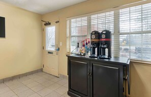 Kitchenette with a coffee maker, water dispenser, and ample storage.
