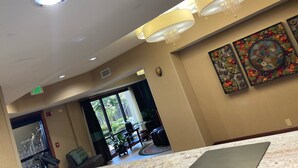 A hotel lobby with a marble reception desk, a chandelier, and a large window with a view of greenery. - Hampton Inn Hot Springs (Hot Springs)