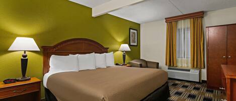 Habitación de hotel con una cama grande, dos mesitas de noche con lámparas, un armario de madera y una ventana con cortinas.