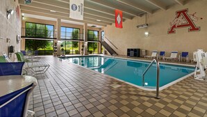 An indoor swimming pool with a checkered floor, lounge chairs, and a large letter 'A' on the wall. - Best Western Windsor Suites (Fayetteville)