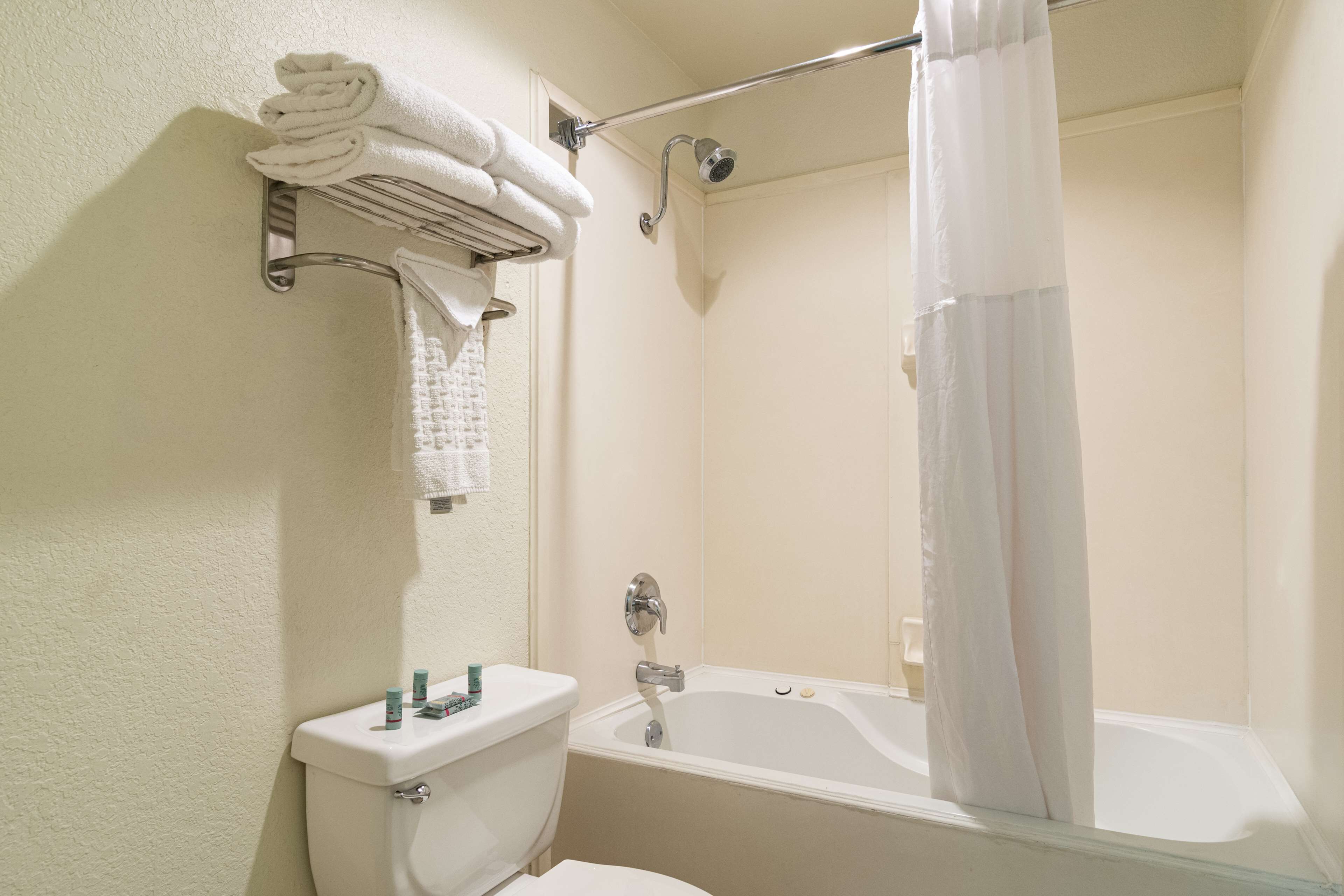 A bathroom with a toilet, a sink, a bathtub, and a shower curtain.