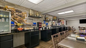 A modern kitchen with a central island, built-in appliances, and a variety of food items displayed on shelves. - Best Western Windsor Suites (Fayetteville)