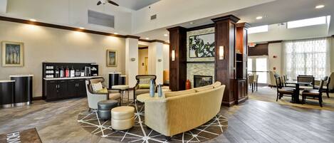 A spacious lobby with a seating area, a coffee station, and a dining area.