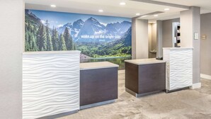 A reception area with a mountain landscape mural, a reception desk, and a waiting area. - La Quinta Inn & Suites by Wyndham Denver Tech Center (Greenwood Village)