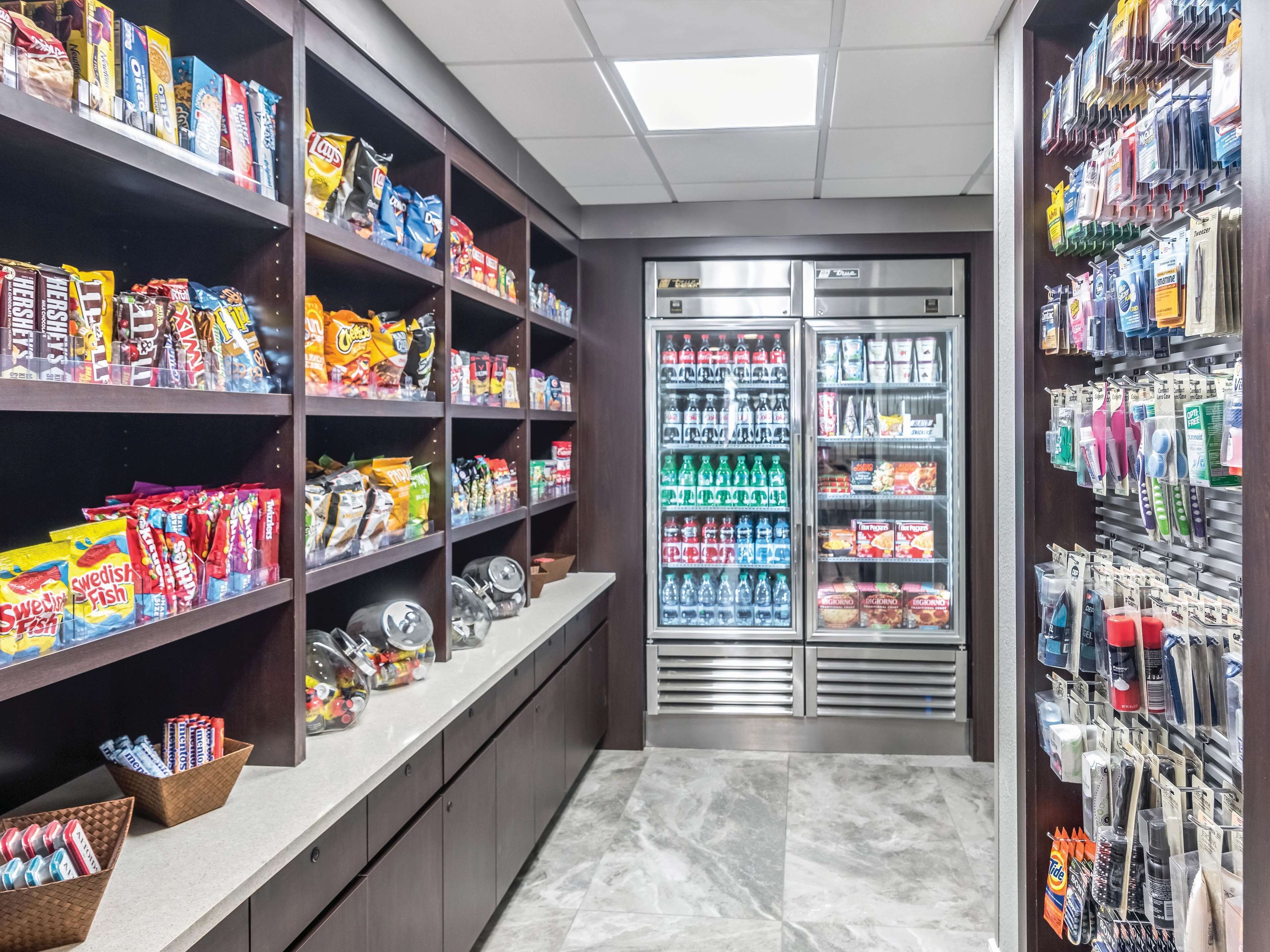 A snack and beverage section with shelves stocked with various snacks and drinks, and a refrigerated display case.