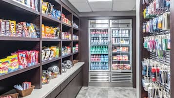A snack and beverage section with shelves stocked with various snacks and drinks, and a refrigerated display case.