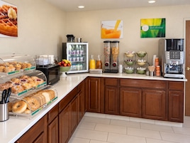 A breakfast buffet with various food items and a coffee machine.