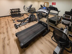 A gym with treadmills, elliptical machines, and a variety of dumbbells. - Quality Inn Winslow I-40 (Winslow)