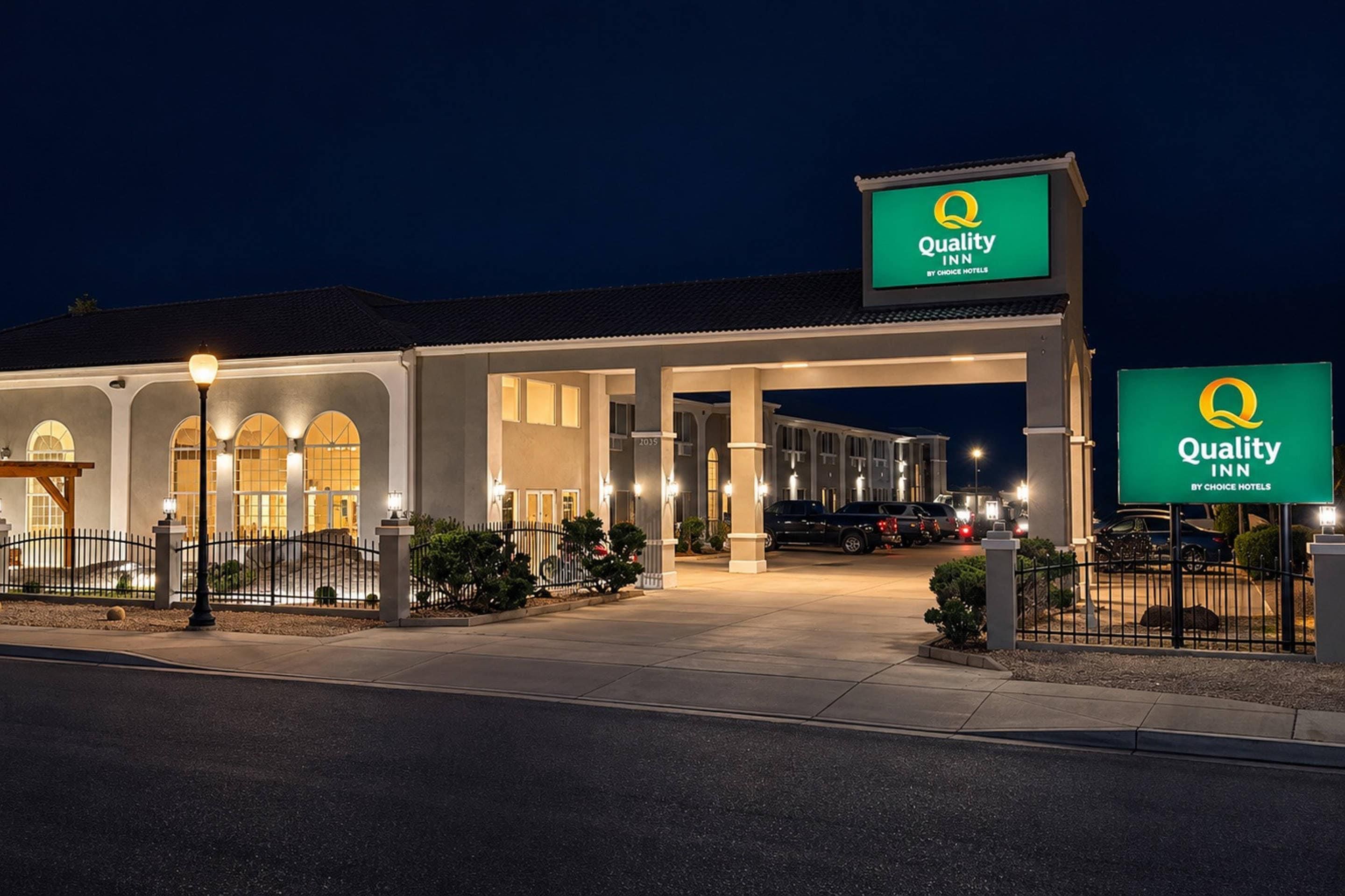 A Quality Inn hotel with a large sign, a covered parking area, and a well-lit entrance.